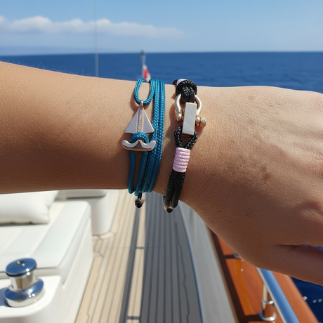 Hand wearing a black bracelet on a boat with ocean view